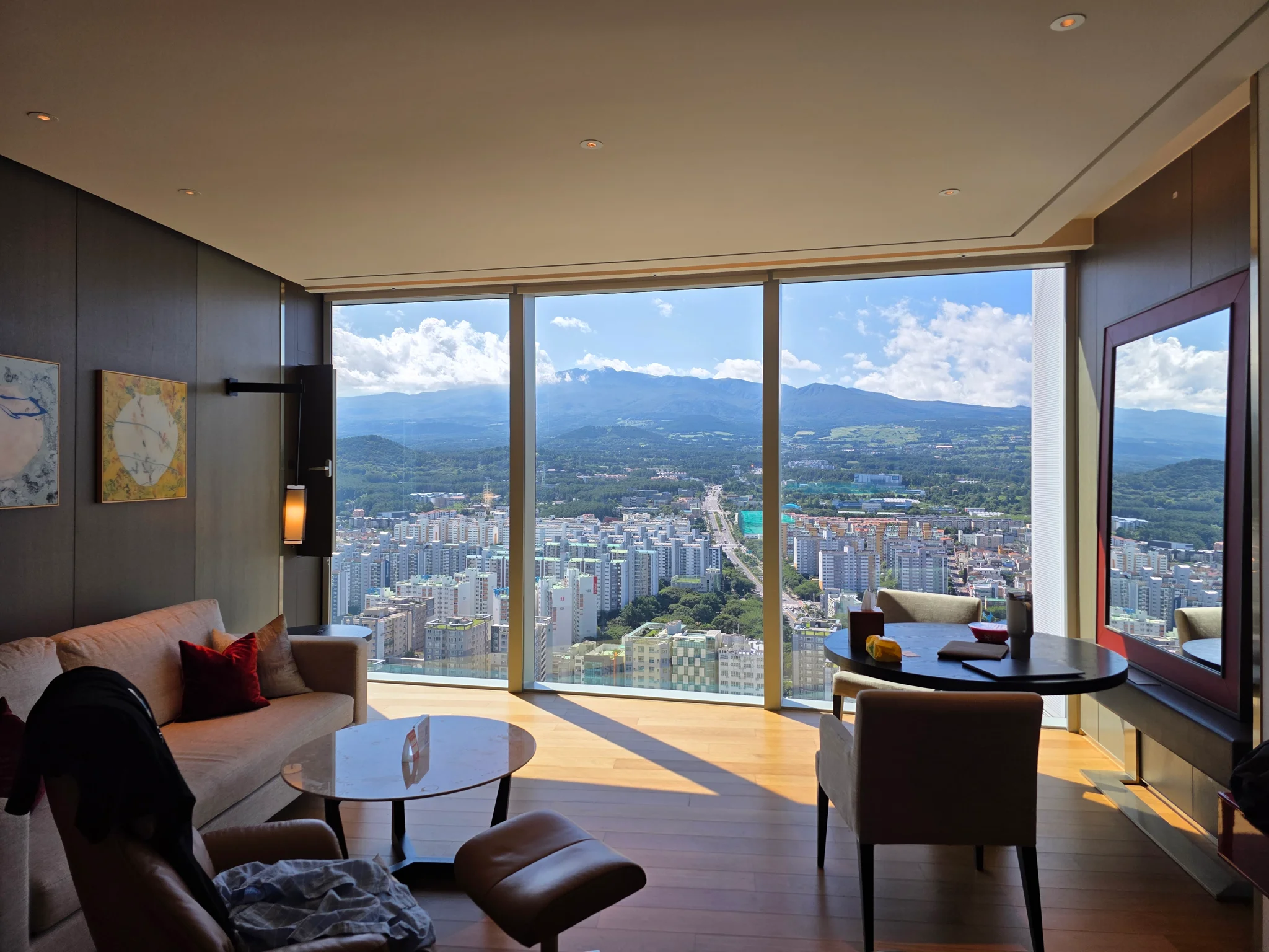 대형 창문으로 도시와 산 전망이 보이는 고층 호텔 객실 내부