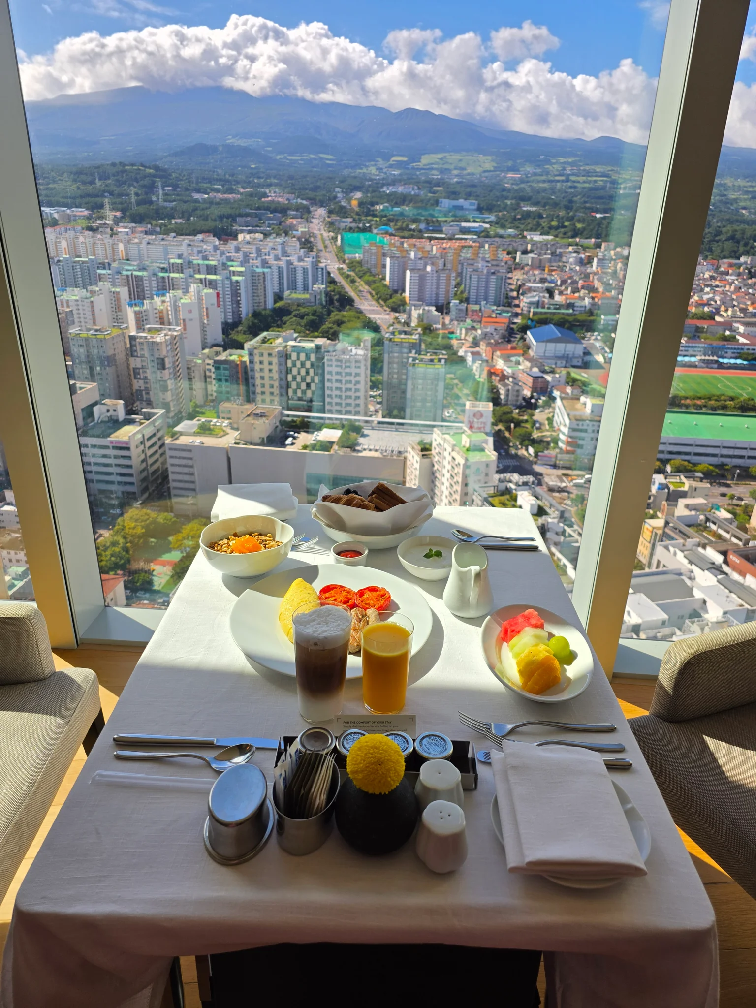 한라산과 제주 시내가 내려다보이는 호텔 레스토랑 창가의 조식 테이블