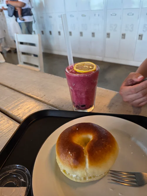 카페 테이블 위의 황금빛 크림빵과 오렌지로 장식된 핑크색 베리 스무디