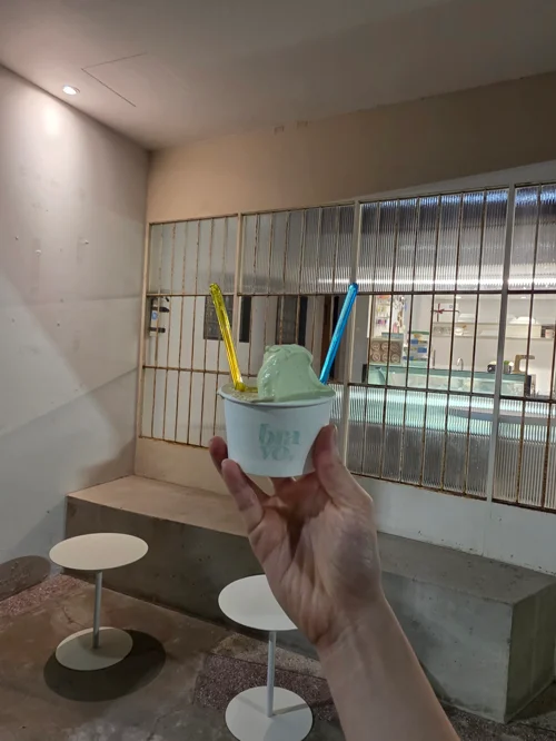 수영장이 보이는 카페에서 민트 아이스크림 컵을 들고 있는 모습