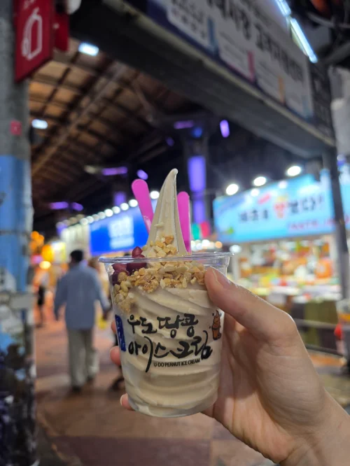 손에 든 소프트 아이스크림 컵과 뒤편 마장동 시장의 야경