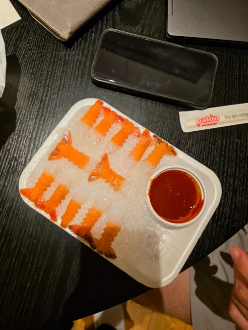 흰 접시에 담긴 연어 초밥 세트와 소스