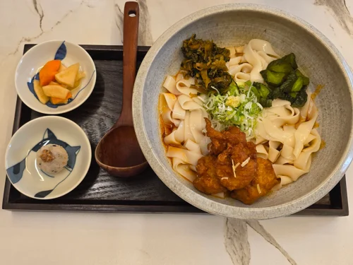 검은 쟁반에 카레우동과 반찬이 담긴 일본식 정식