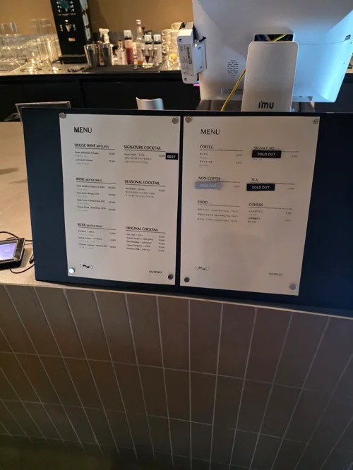 바 카운터 위에 놓인 두 개의 메뉴판, 주류와 음료 메뉴가 표시되어 있음
