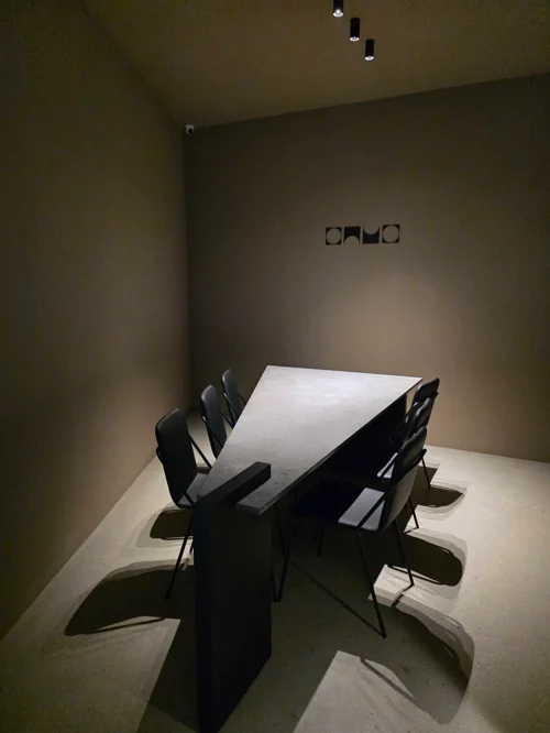 흰색 테이블과 검은색 의자가 배치된 미니멀한 다이닝 공간