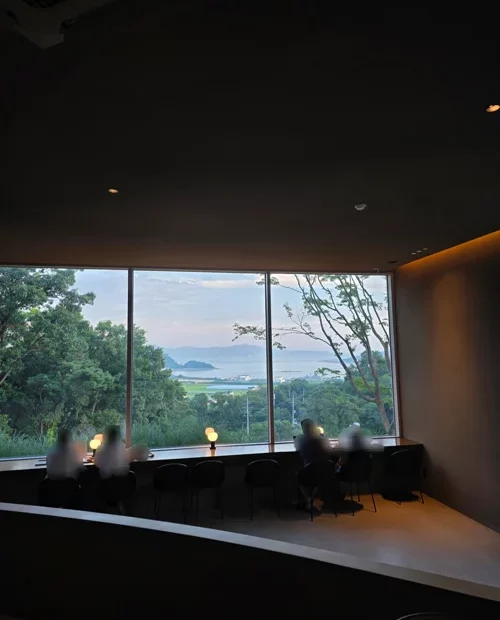 통창 너머 바다와 녹음이 보이는 카페 창가 좌석