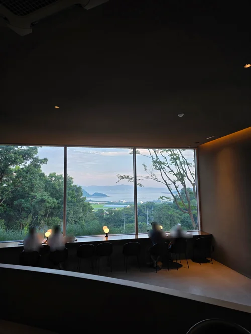 통창 너머 바다와 녹음이 보이는 카페 창가 좌석