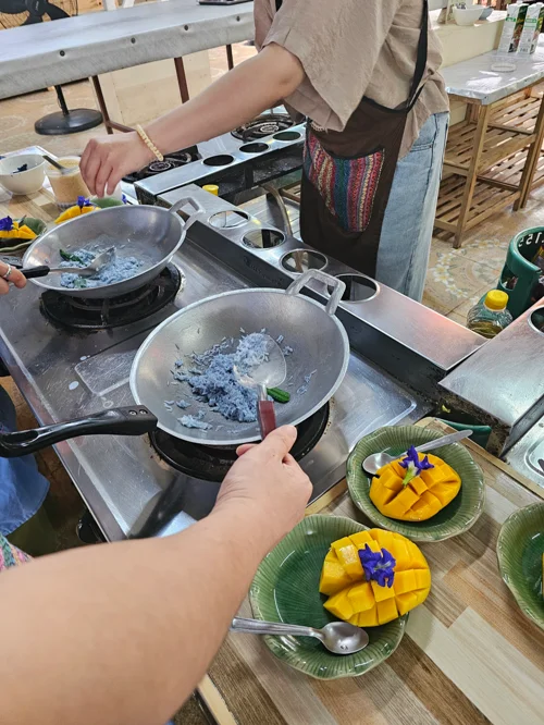 태국 쿠킹 클래스에서 프라이팬으로 요리하고 망고 디저트를 준비하는 모습