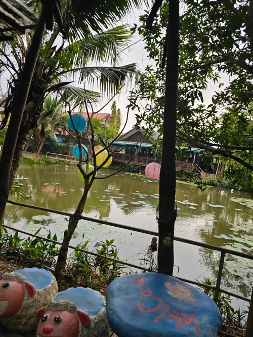 연못가 테라스의 버섯 조형물과 수상가옥이 있는 열대 정원 풍경