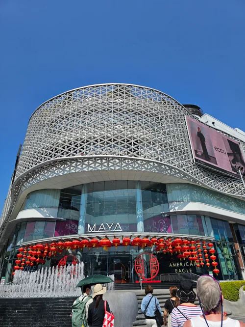 기하학적 메탈 외관과 빨간 등롱 장식이 있는 MAYA 쇼핑몰 전경