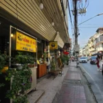 노란 간판의 팟타이 전문점이 있는 태국 거리 풍경