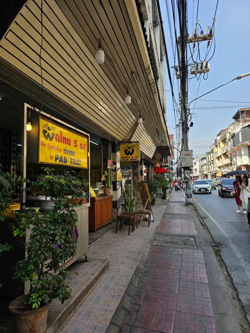 노란 간판의 팟타이 전문점이 있는 태국 거리 풍경