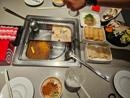 2단 샤브샤브 냄비와 다양한 재료가 놓인 훠궈 테이블