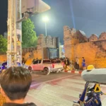 밤에 황금빛 조명으로 비춰진 치앙마이 타페 게이트 성곽과 사람들