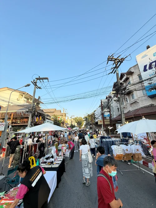 도로를 따라 흰색 텐트가 늘어선 플리마켓에서 사람들이 쇼핑을 즐기는 모습