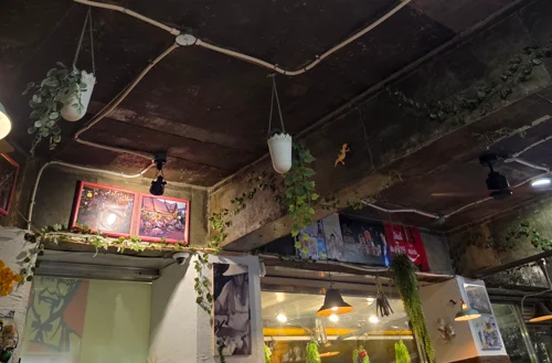 구리 파이프 조명과 펜던트 조명이 설치된 빈티지 카페 천장