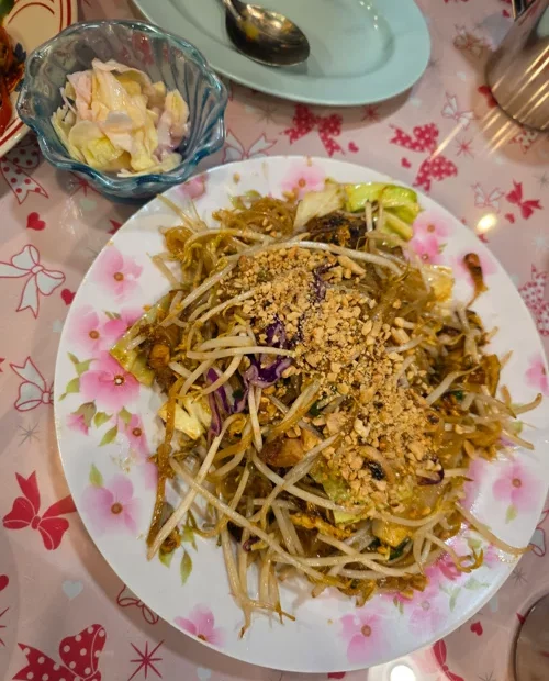 땅콩가루가 뿌려진 팟타이 쌀국수 요리와 절임 반찬