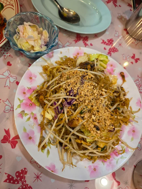 땅콩가루가 뿌려진 팟타이 쌀국수 요리와 절임 반찬