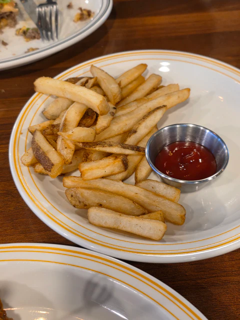 금색 테두리 접시에 담긴 감자튀김과 케첩