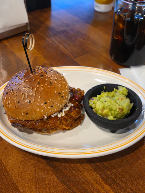 참깨가 뿌려진 햄버거와 과카몰리가 담긴 접시