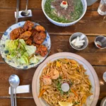 테이블 위 팟타이, 닭강정, 쌀국수가 담긴 베트남 식사 세팅