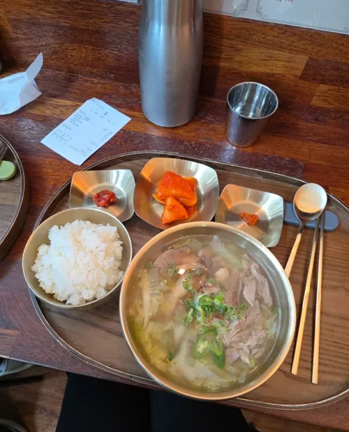 스테인리스 쟁반에 국물요리와 밥, 반찬이 담긴 한식 정식