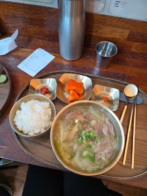 스테인리스 쟁반에 국물요리와 밥, 반찬이 담긴 한식 정식