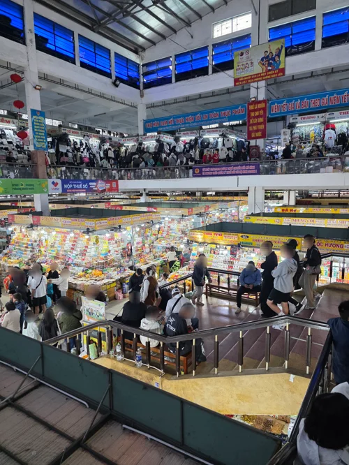 베트남 한시장 내부의 화려한 상품 진열대와 쇼핑객들