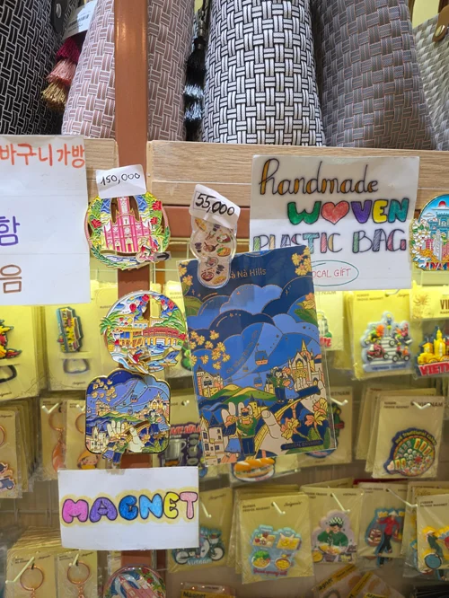 베트남 전통 문양이 새겨진 다양한 수공예 기념품과 자석이 진열된 가게 쇼윈도