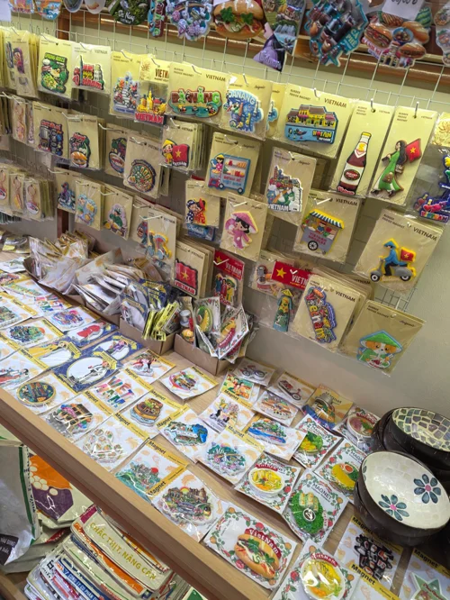 벽면과 테이블에 빈티지 캐릭터 스티커와 완구들이 진열된 레트로 문방구 코너