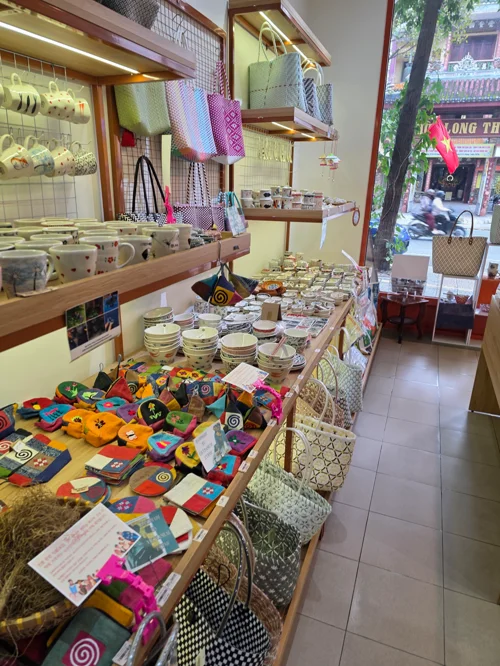 형형색색의 자수 쿠션과 도자기가 진열된 베트남 수공예품 가게 내부