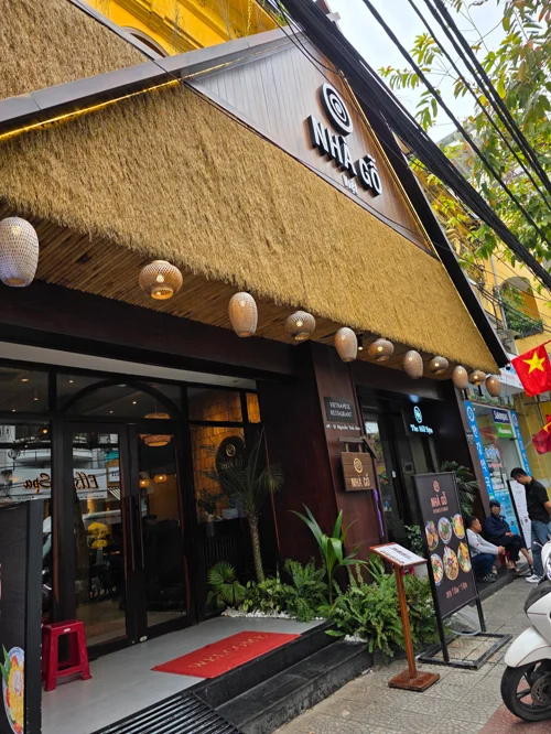 노란 벽과 짚 지붕, 대나무 조명이 있는 베트남 레스토랑 외관