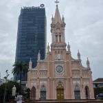 분홍색 고딕 양식의 다낭 대성당과 뒤편의 VietinBank 고층 빌딩