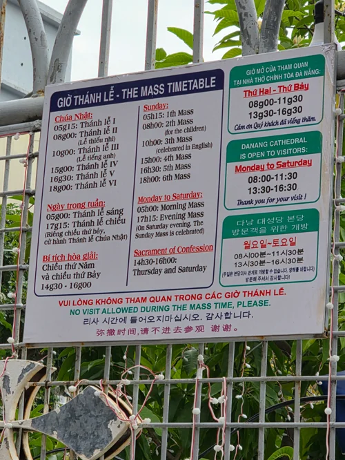 다낭 대성당 입구의 다국어 미사 시간표 안내판