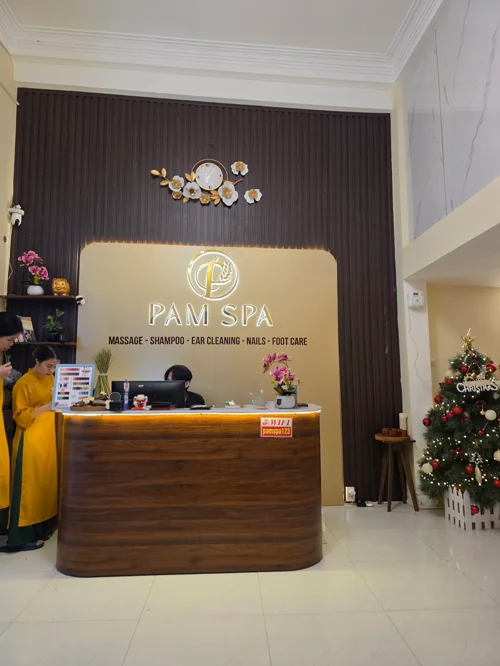 PAM SPA 로고가 새겨진 리셉션 데스크와 크리스마스 장식이 있는 스파 입구