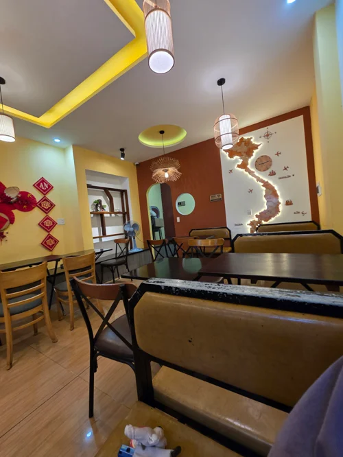 베트남 지도 장식과 노란 천장 조명이 있는 레스토랑 식사 공간