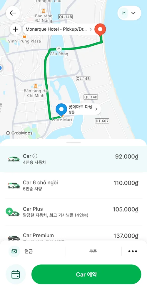 그랩 앱 화면에 다낭 모나크 호텔에서 롯데마트까지의 경로와 4가지 차량 옵션 및 요금이 표시됨