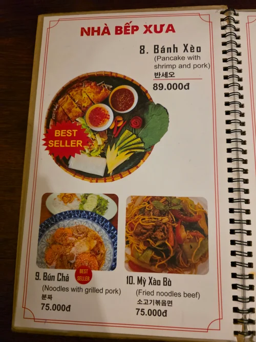 베트남 음식점 메뉴판에 반쎄오 89,000동, 분짜 75,000동, 미사오보 75,000동이 사진과 함께 표시됨
