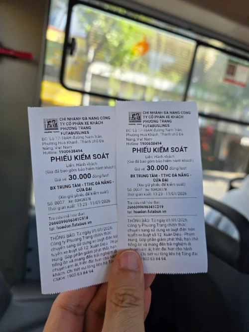 다낭 시내버스 티켓 두 장을 손에 들고 있는 모습