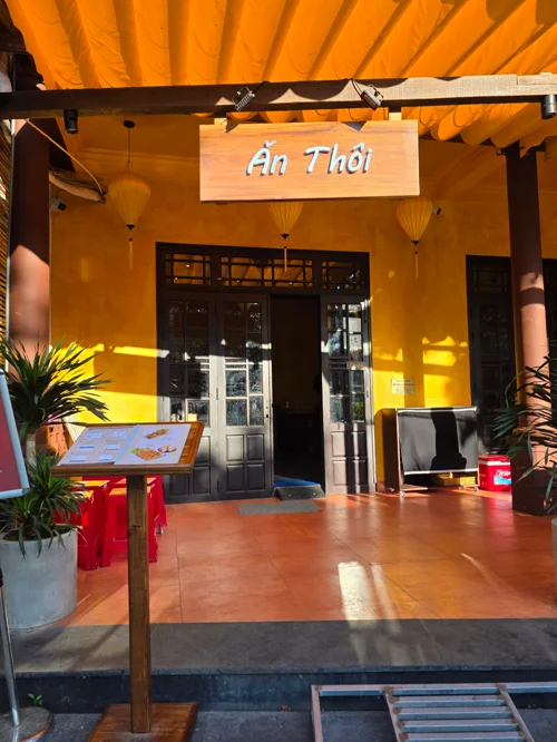 노란색 조명과 차양이 있는 베트남 레스토랑 안토이 입구 전경