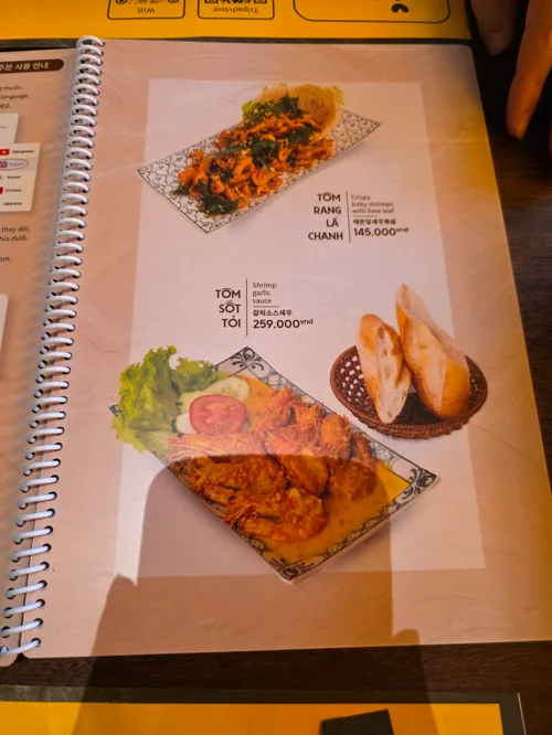 새우 튀김과 마늘 새우 등 해산물 요리 사진이 담긴 베트남 레스토랑 메뉴판