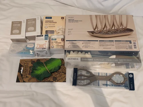 침대 위에 정돈된 친환경 생활용품 박스와 나무 옷걸이 세트