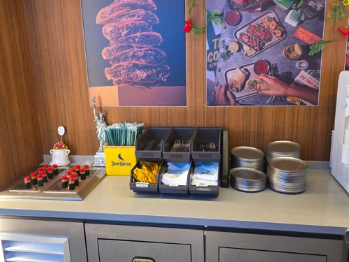 레스토랑 셀프 서비스 카운터에 빨대통과 음료 디스펜서가 놓여있는 모습