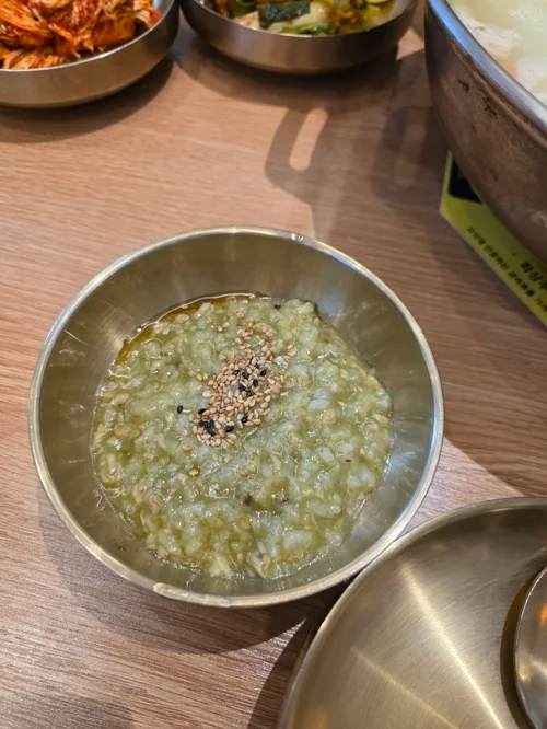 스테인리스 그릇에 깨가 뿌려진 녹두죽