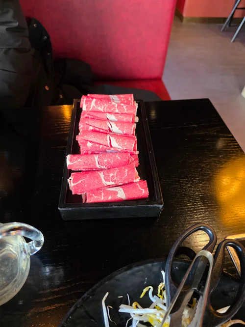 검은 접시에 담긴 신선한 소고기 슬라이스