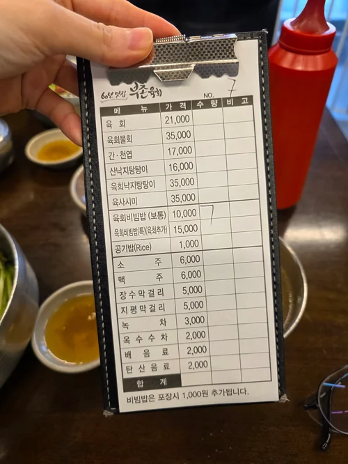 육회 전문점 우육당의 메뉴판을 손으로 들고 있는 모습