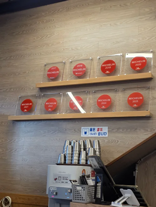 2017년부터 2025년까지 9년 연속 미슐랭 선정 플라크가 전시된 레스토랑 내부 벽면