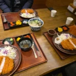 나무 트레이 위에 돈까스와 밥, 우동이 세팅된 일본식 정식