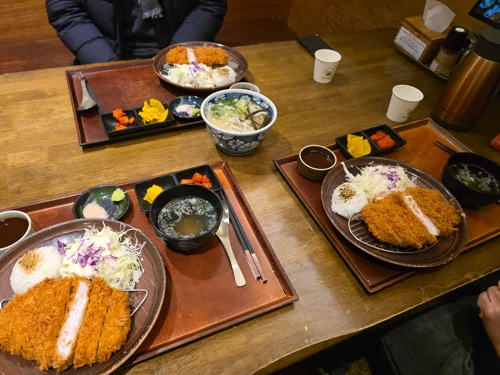 나무 트레이 위에 돈까스와 밥, 우동이 세팅된 일본식 정식