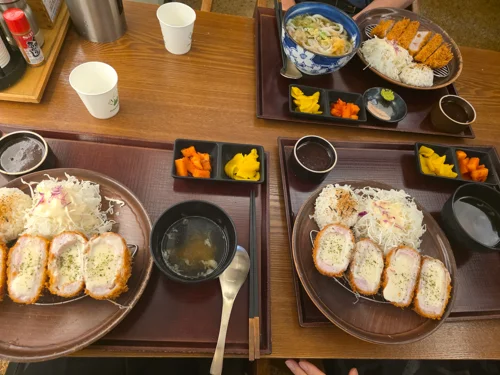 나무 쟁반에 담긴 돈카츠 정식 두 세트, 밥과 카레, 단무지, 된장국 포함